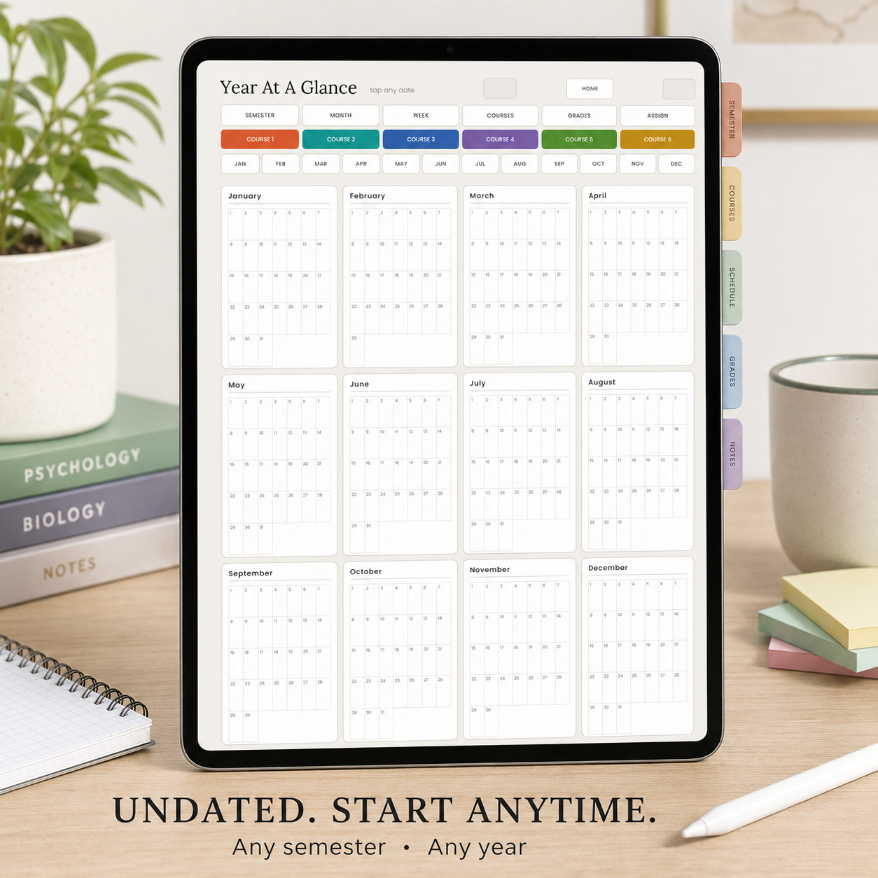 A tablet on a desk displaying a semester calendar titled 'Year At A Glance' with monthly grids and colored tabs. 